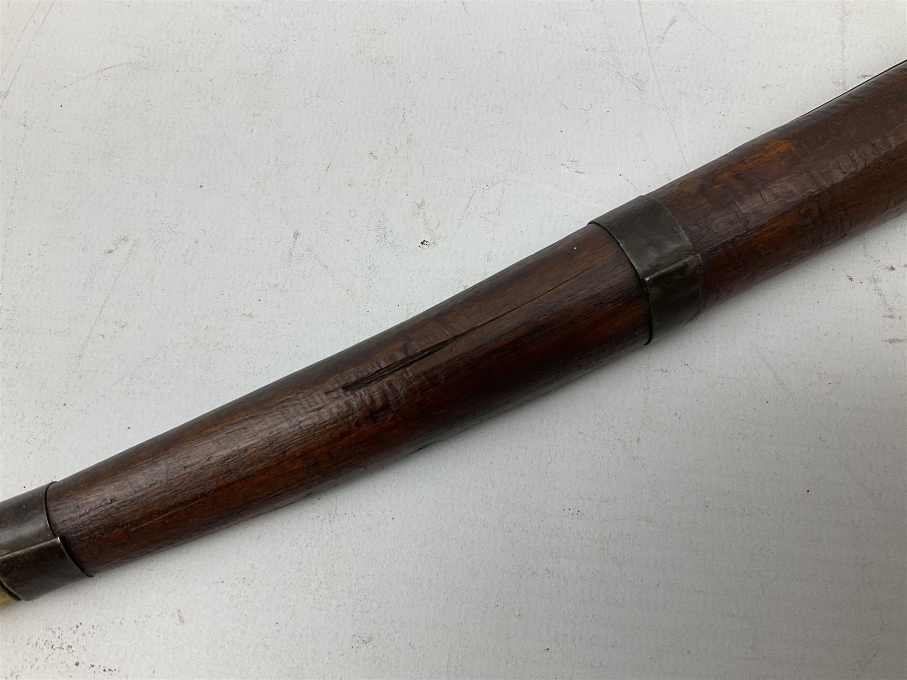 19th century Algerian Flyssa long knife, the 34cm single edged pointed decorative blade inset with yellow metal, chased brass grip with pommel as the snout of a stylised animal and carved hardwood scabbard L45cm overall