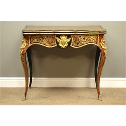  Mid 19th century French ebonised and red boulle card table, baise lined swivel fold over serpentine top with scrolling pierced brass inlay with ormolu bead, the shaped apron with acanthus leaf and mask, on cabriole supports with cherub and floral moulded ormolu mounts, W87cm, H75cm, D44cm  