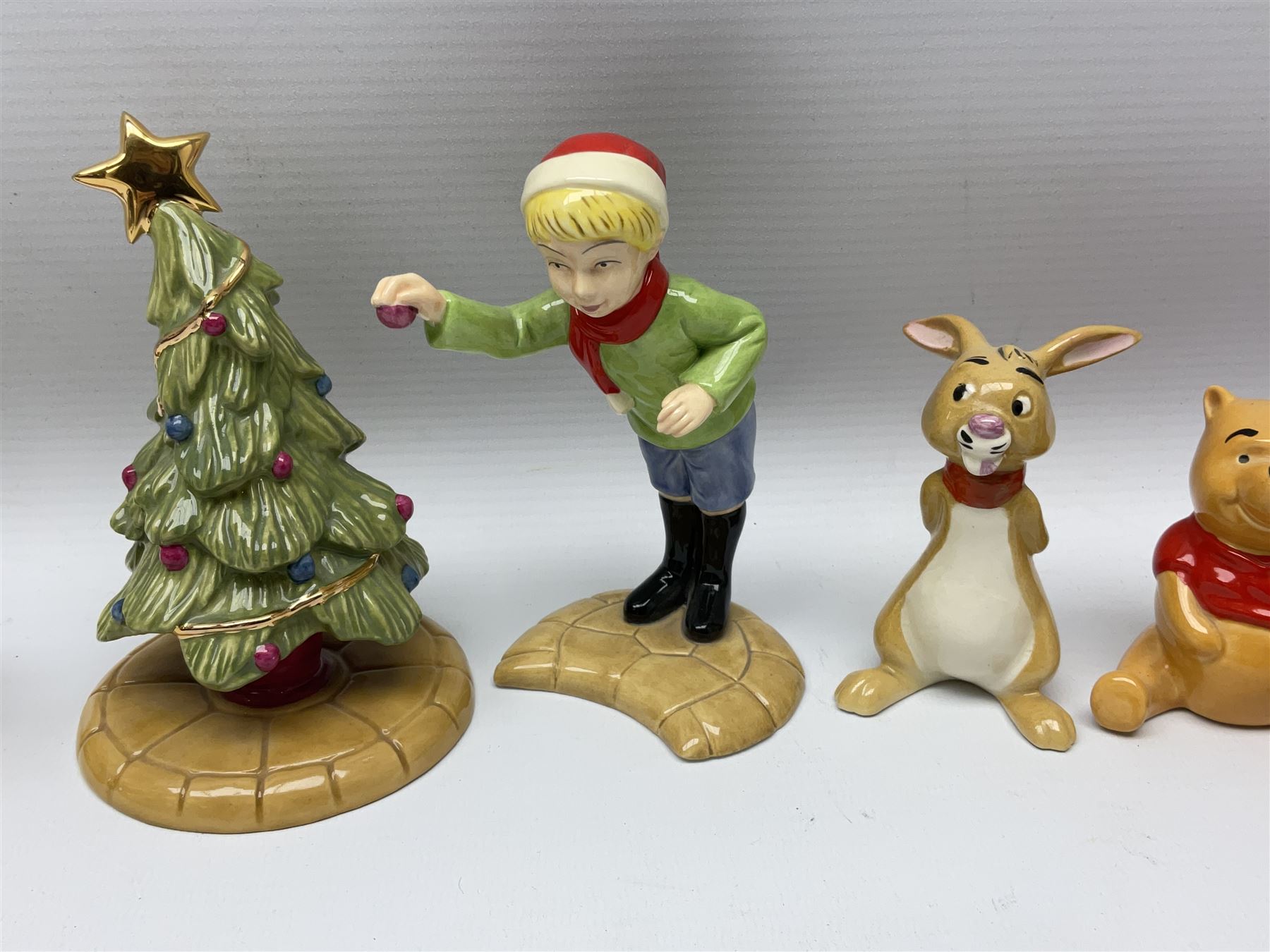 Seven Beswick Winnie the Pooh figures, comprising Pooh Bear, Tigger, Piglet, Kanga, Mr Rabbit, Owl, and Eeyore, together with two Royal Doulton Winnie the pooh Christmas Collection figures, 'The Most Perfect Tree in all the Wood', and 'Christopher Robin Dresses the Tree', (9)  