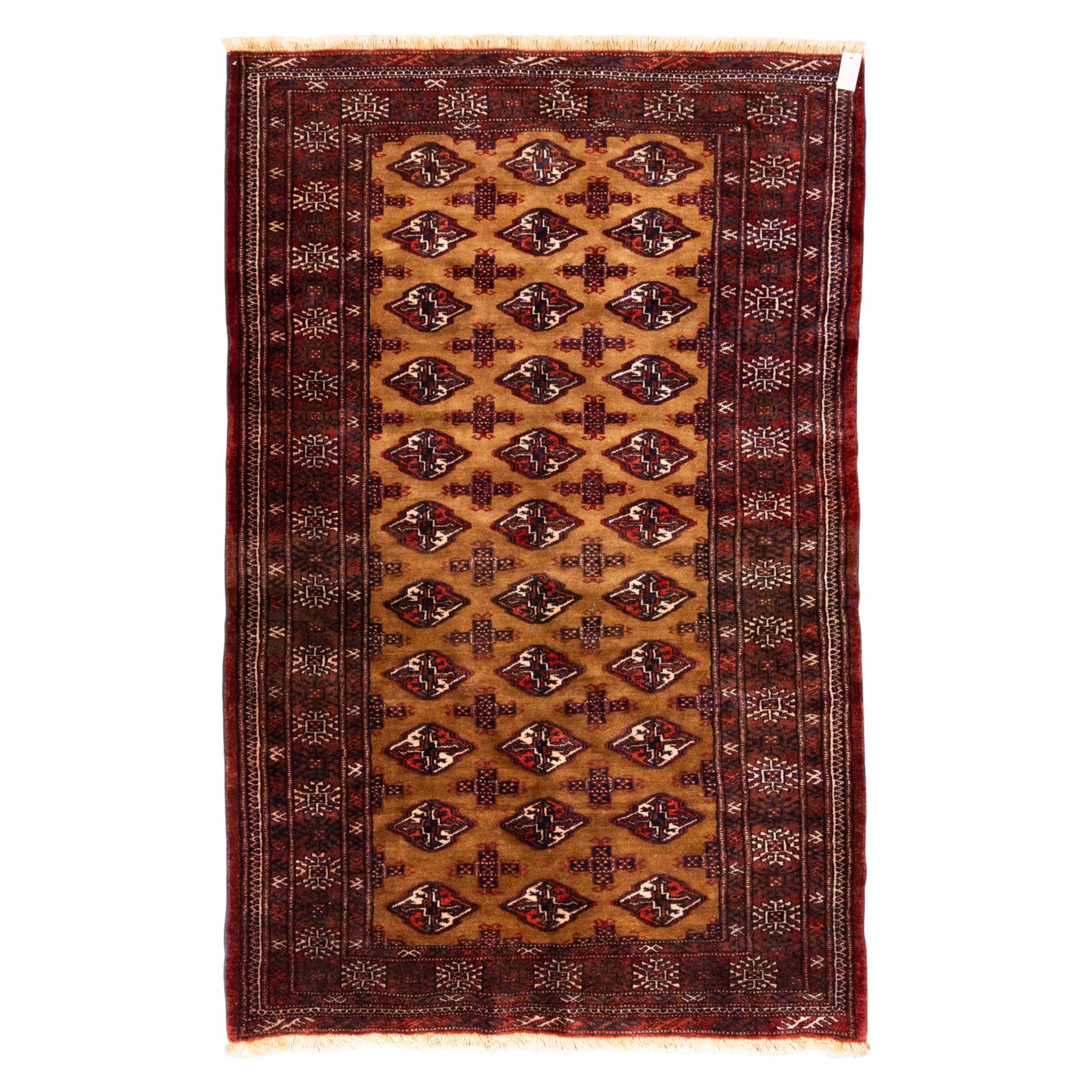 North East Persian Turkoman hand-knotted rug, camel brown field decorated with repeating rows of octagonal guls, interspersed with small geometric motifs enclosed within narrow guard borders in a palette of madder red, brown, and ivory, with cotton fringe ends  