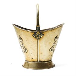 Art Nouveau brass log bucket of oval design with swing handle and a raised pattern of stylised flowers H29cm