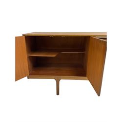 Tom Robertson for AH McIntosh & Co of Kirkaldy - mid-20th century teak sideboard, fitted with four central drawers, flanked by cupboard enclosing shelves and sliding tray, raised on cylindrical supports