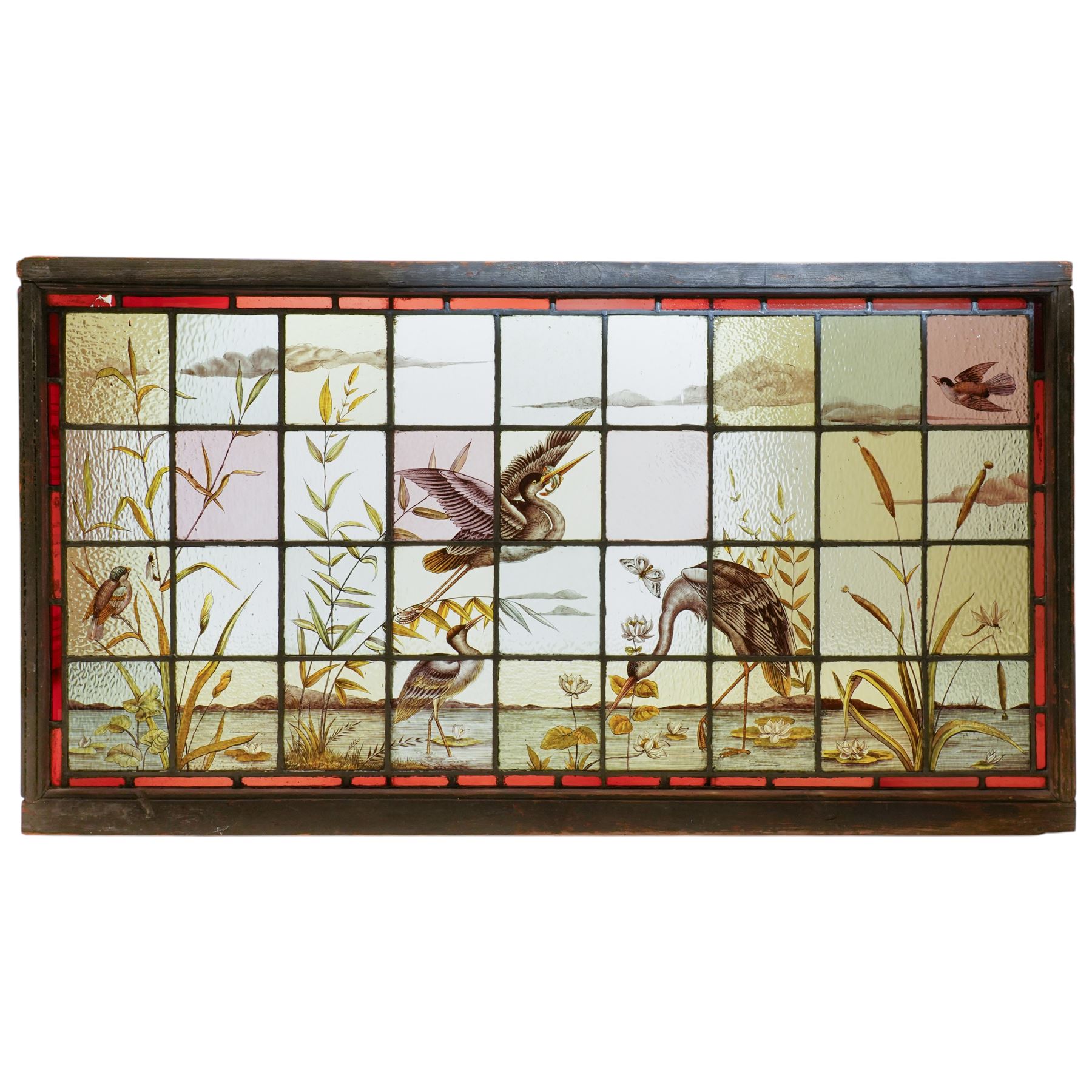 Large Victorian Aesthetic movement stained glass leadlight window panel, hand painted with a scene of herons and other birds in a lake, overall 82cm x 147cm 
