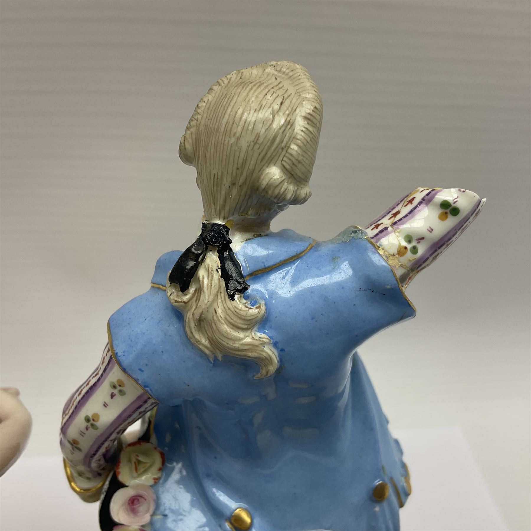 Pair of late 19th/early 20th Century Meissen figures, modelled as flower sellers, after the original by Michel Victor Acier, she holding basket of flowers, he holding flowers in his hat, each with underglaze cross swords mark beneath, tallest H16.5cm