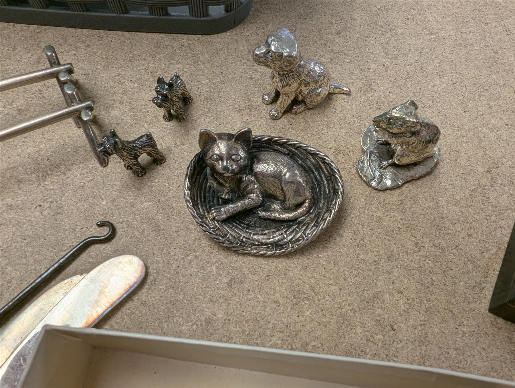 Pair of silver knife rests, two silver handled butter knives and a silver handled button hook, all hallmarked, together with a silver onyx pendant and ring, white metal figures and coins etc 