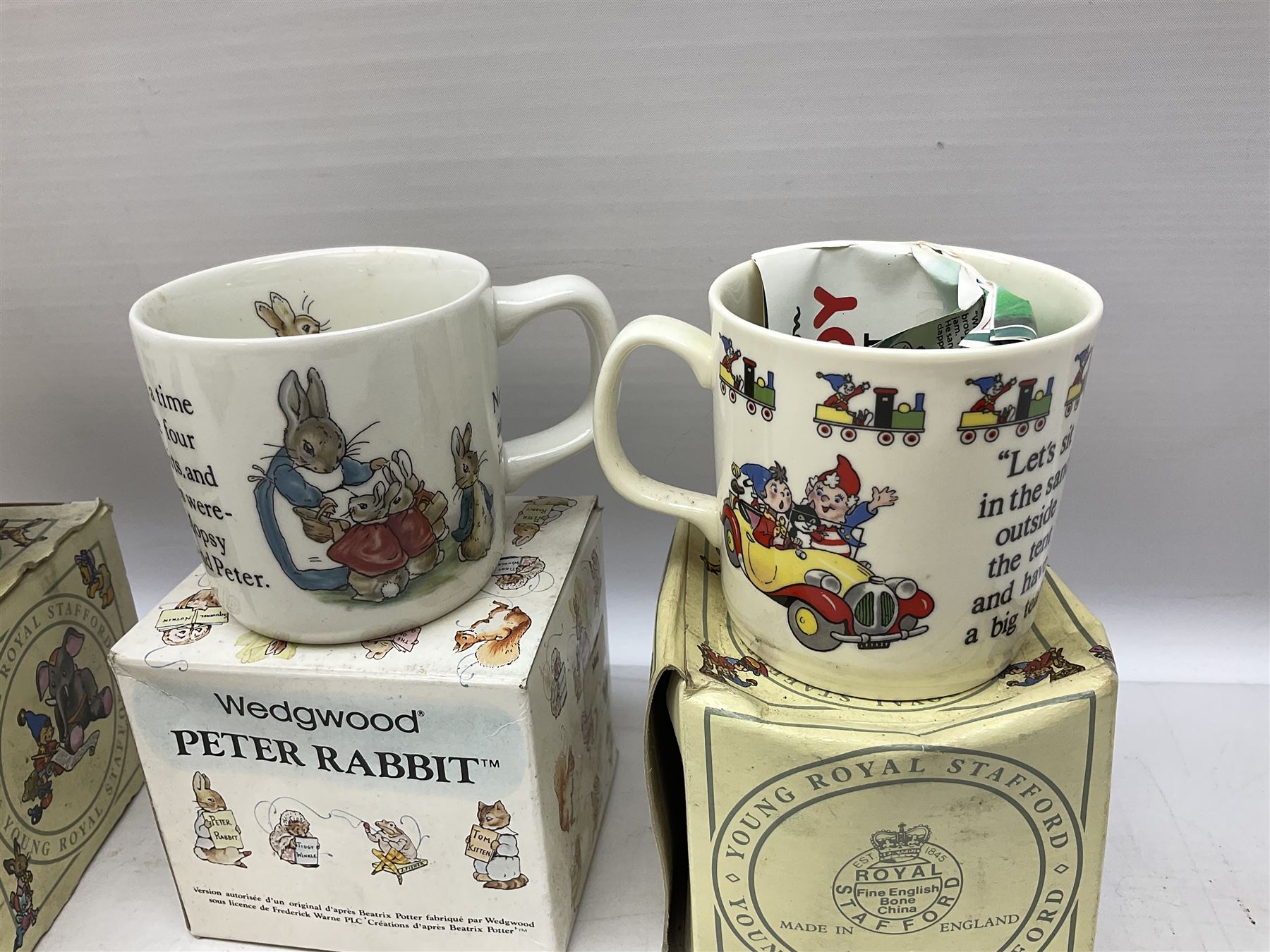 Royal Doulton Bunnykins nursery set in box and two cups, together with two Wedgwood Peter Rabbit mugs and Royal Staffordshire Noddy money box and cup (7)
