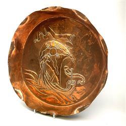 A Newlyn School style large circular copper dish, the raised rim with crimped edge and repousse study of a Viking long ship in a rough sea, unmarked, D41cm.