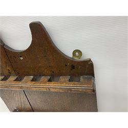 George III oak spoon rack and candle box, the rectangular backplate with shaped  pediment and two six aperture spoon racks, above a candlebox with hinged cover, with various brass spoons and a pair of brass candle snuffers, H56.5cm, W35cm, D14cm 