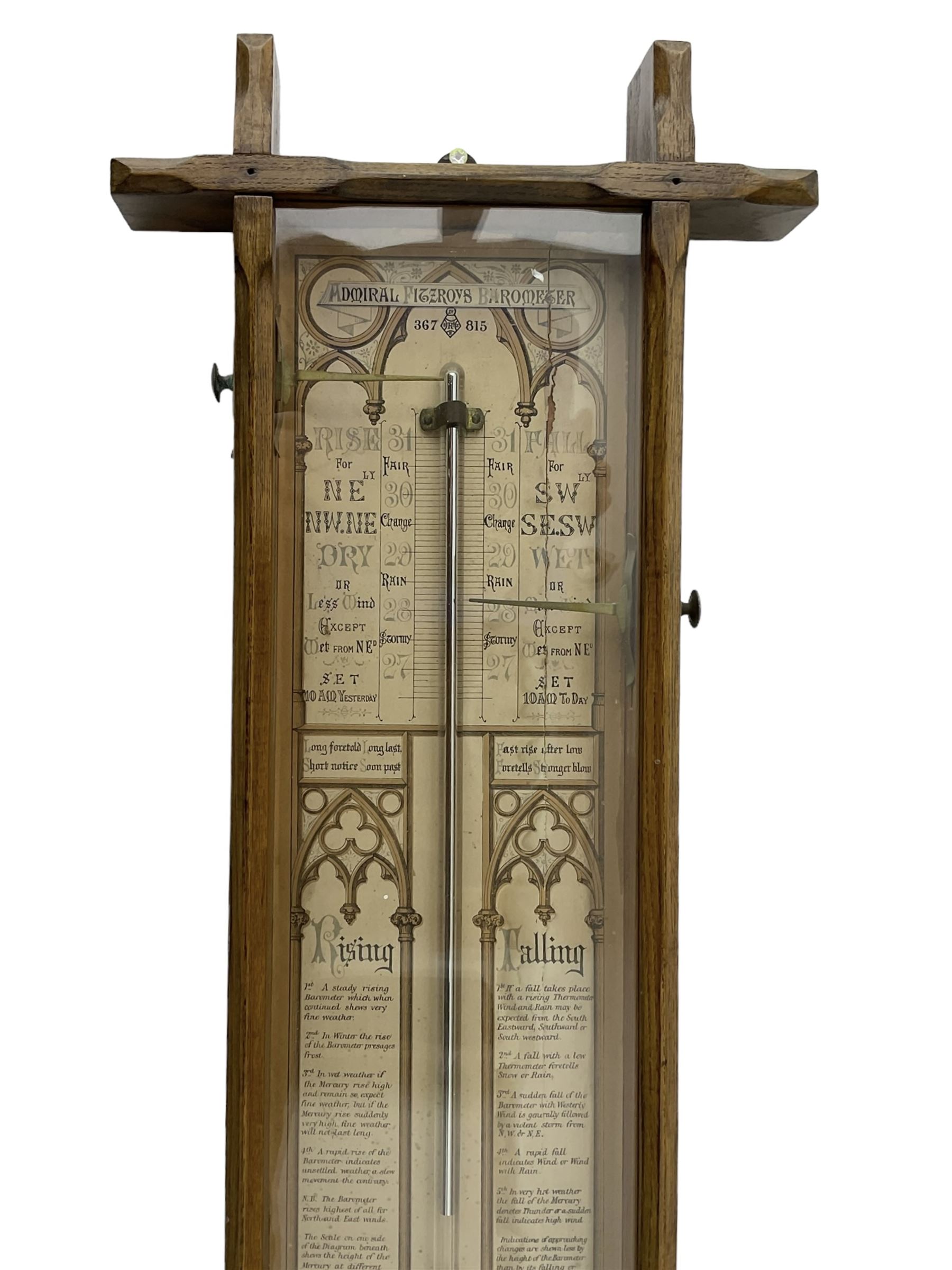 Admiral Fitzroy - Early 20th century Fitzroy barometer in a glazed gothic influenced oak case with chamfered uprights and top and base panels, full length paper scales with Fitzroy's observations and predictions, mercury bulb cistern, storm glass, spirit thermometer and brass sliding vernier pointers. Retailed by Inglis & Son, Coney Street, York.