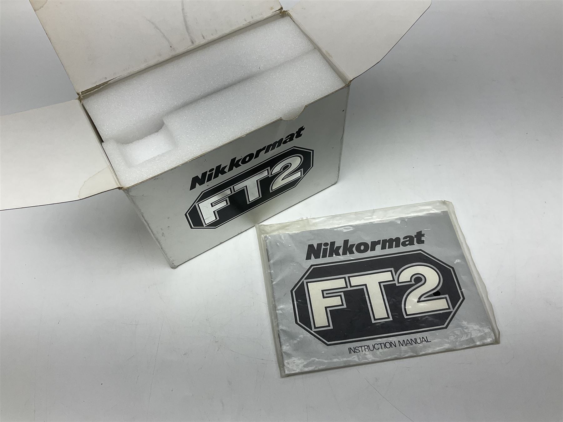 Nikkormat FT2 camera body, serial no. 5066813, in original packaging, together with Nikkormat EL camera body, serial no. 5577358, with Nikon Nikkor 50mm 1:1.8' lens no. 2143575, Nikkormat FT, serial no. 3968385, and Nikomat FT camera body, serial no. 4015491
