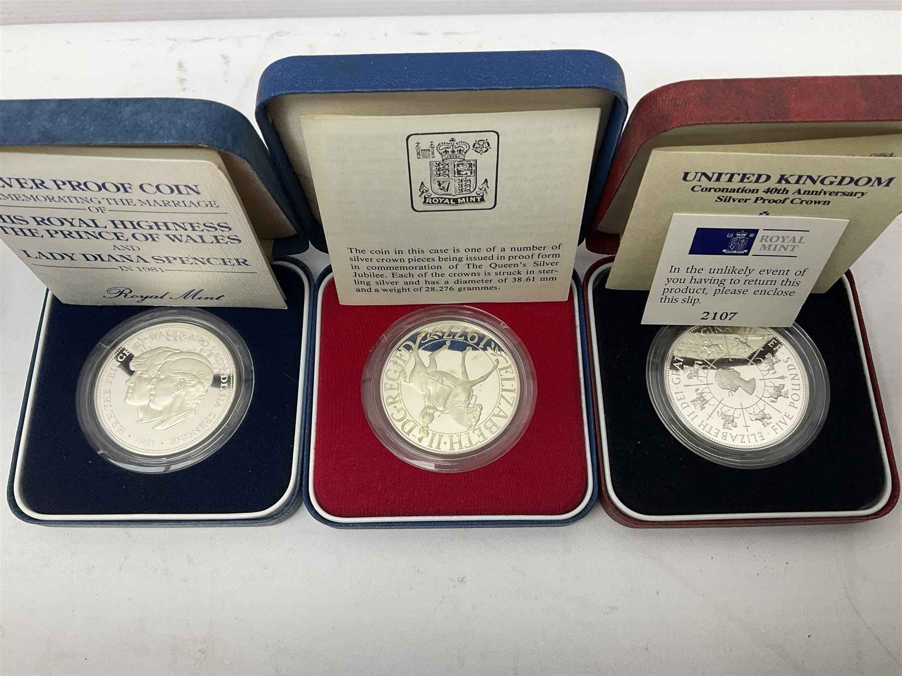 Seven The Royal Mint United Kingdom sterling silver proof crown coins, comprising two 1972, three 1977, 1981 and 1993, all cased with certificates and a Queen Elizabeth II 2001 one ounce fine silver Britannia coin on card (8)