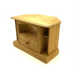 Small pine corner television stand, fitted with central short drawer surrounded by compartments, raised on plinth base  