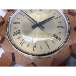 Mid-century teak sunburst wall clock by Anstey & Wilson, modelled with angular teak rays spreading from circular mount with plain brass face with Roman numerals, with battery operated Japanese movement, D45cm