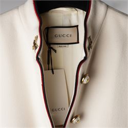 Gucci - bee embroidered wool single-breasted military coat, from the Autumn/Winter 2017 collection under Alessandro Michele, in ivory, with stand collar, red and navy trim, pearlescent and gold-tone button fastening and embroidered bee detailing to the collar, size 14, unused with original garment bag and tags