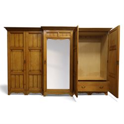 Gothic revival ash breakfront wardrobe in the manner of Charles Bevan, the four fielded panelled doors flanking a central mirrored door, opening to reveal an fitted interior with hanging rails and compartment shelves and drawers, upon a shaped plinth base with bracket cut feet

