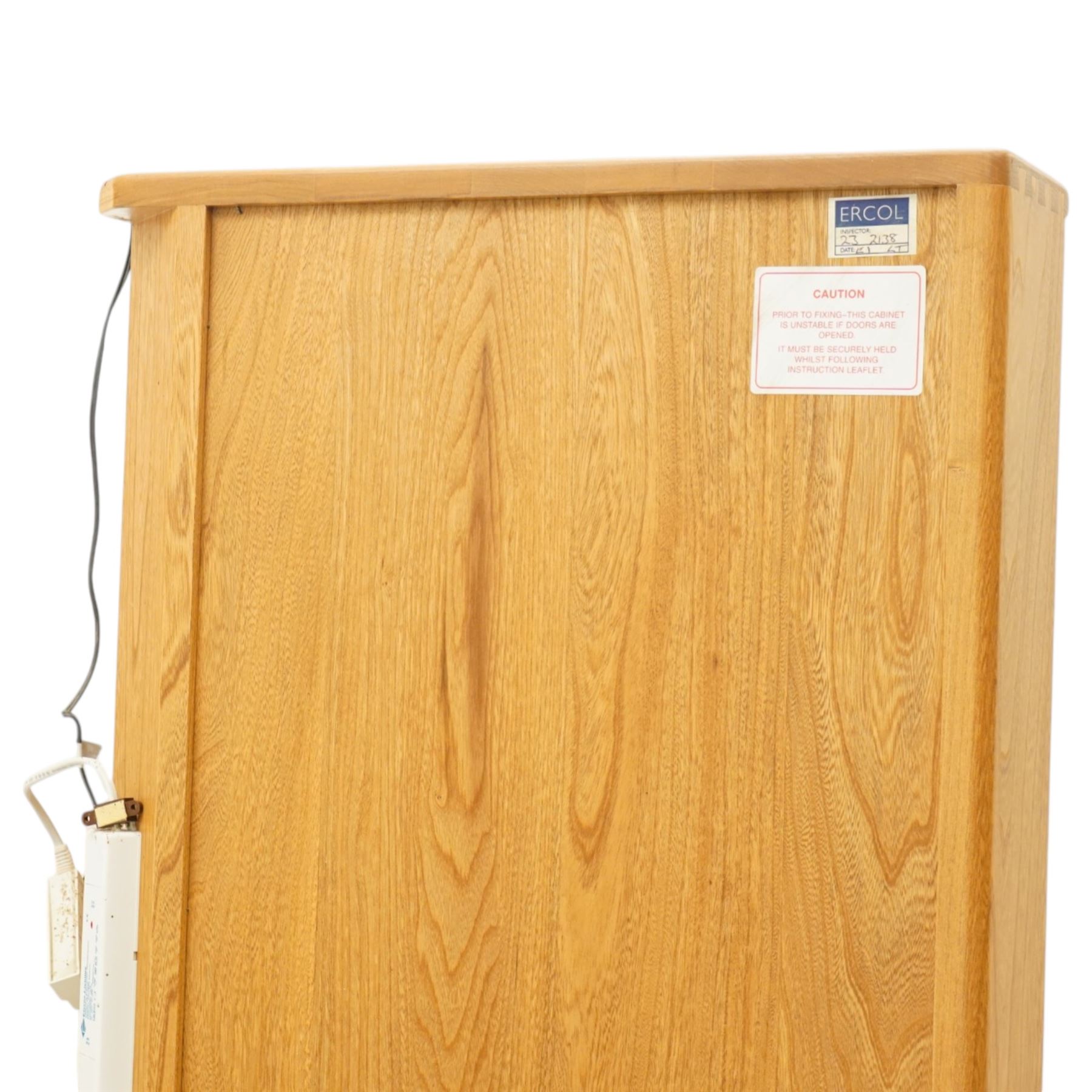 Ercol - elm corner display cabinet, Model 3856. Glazed upper section with glass door enclosing two glass shelves and interior light, above panel cupboard door, with rounded uprights and circular turned handles, on plinth base