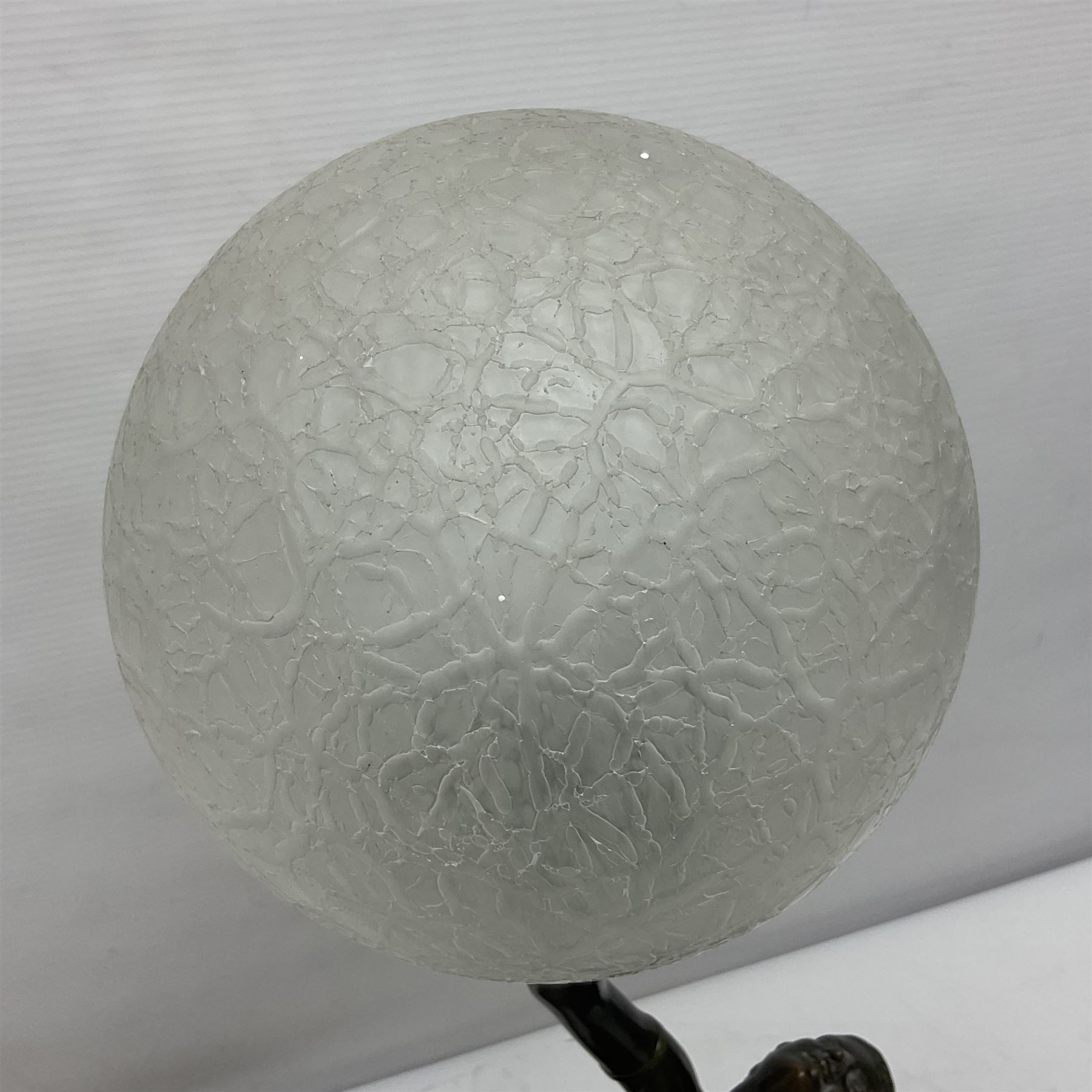 1930s Art Deco spelter table lamp, modelled as a nude woman holding aloft a spherical crizzled glass shade, upon a marble base, H48cm
