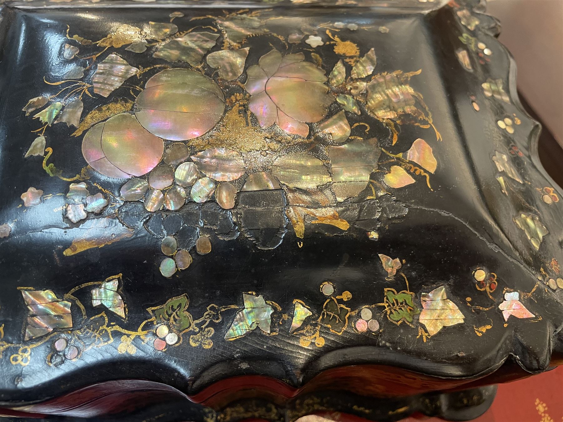 Victorian black lacquered papier-mâché sewing box, of rectangular form with shaped sides, the slightly domed top with inlaid mother of pearl and abalone decoration, the sides with gilt and polychrome painted scrollwork, the hinged cover opening to reveal a fitted interior with lift out tray, H14cm