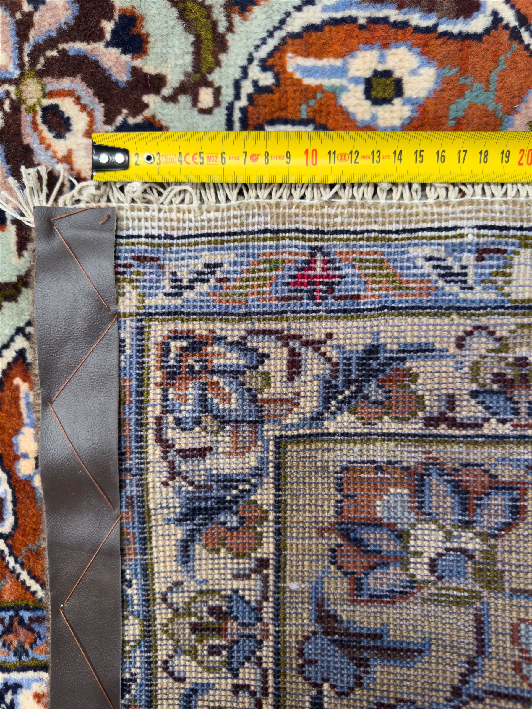 Central Persian Najafabad hand-knotted carpet, the ivory field with a central floral medallion radiating palmettes and arabesques in tones of blue, lilac and tan, enclosed by a wide navy border of scrolling vine and rosette motifs, with red spandrels and multiple guard stripes