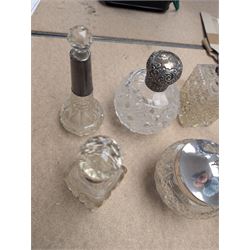 Collection of silver mounted glass bottles and jars, including decanter with etched floral decoration and silver collar, four scent bottles with silver caps, etc all hallmarked 