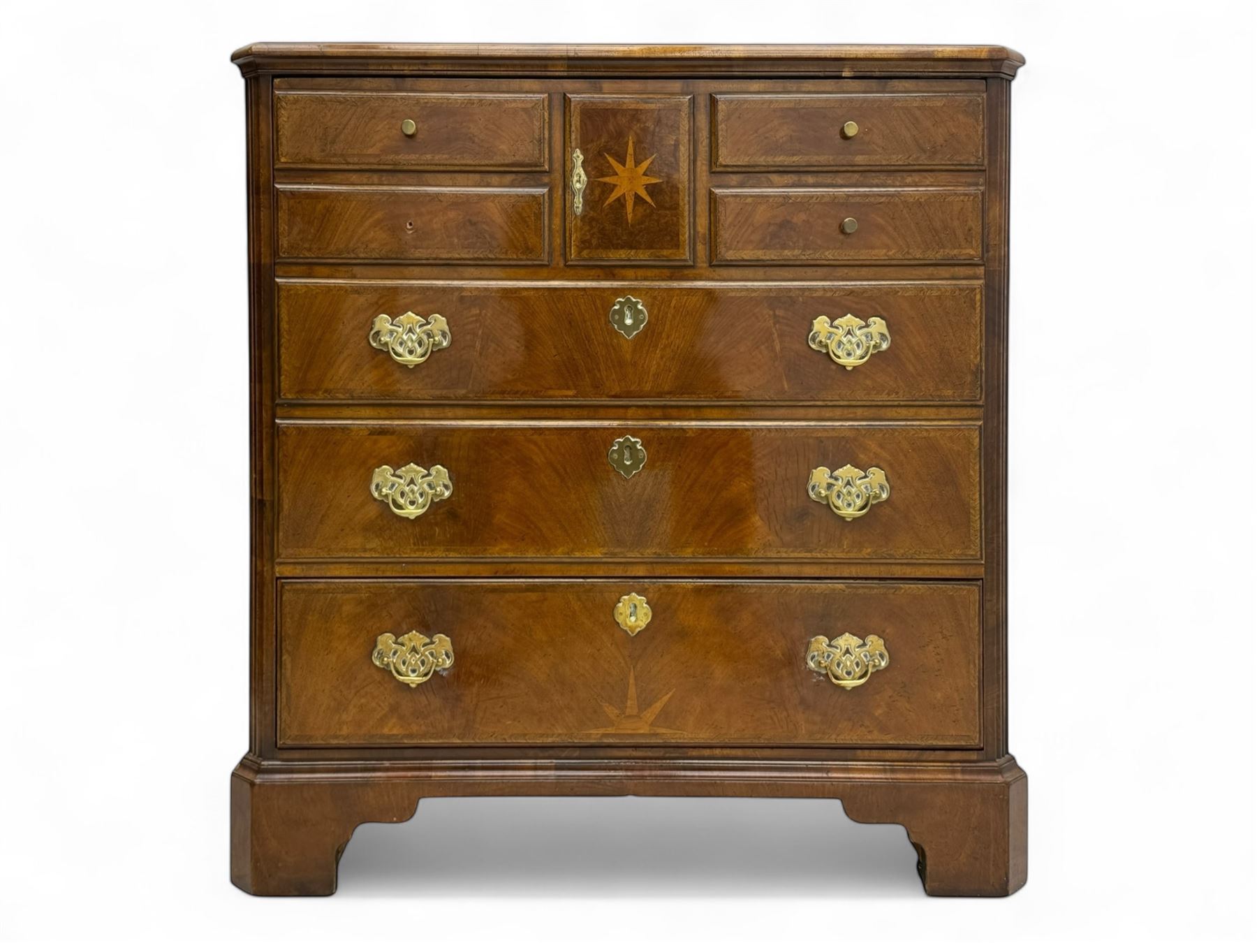 Late 20th century walnut veneered television chest in Georgian style, rectangular top over simulated drawer front with central marquetry star inlay, opening to a shelved TV compartment, lower section fitted with one long drawer, brass handles and ogee bracket feet