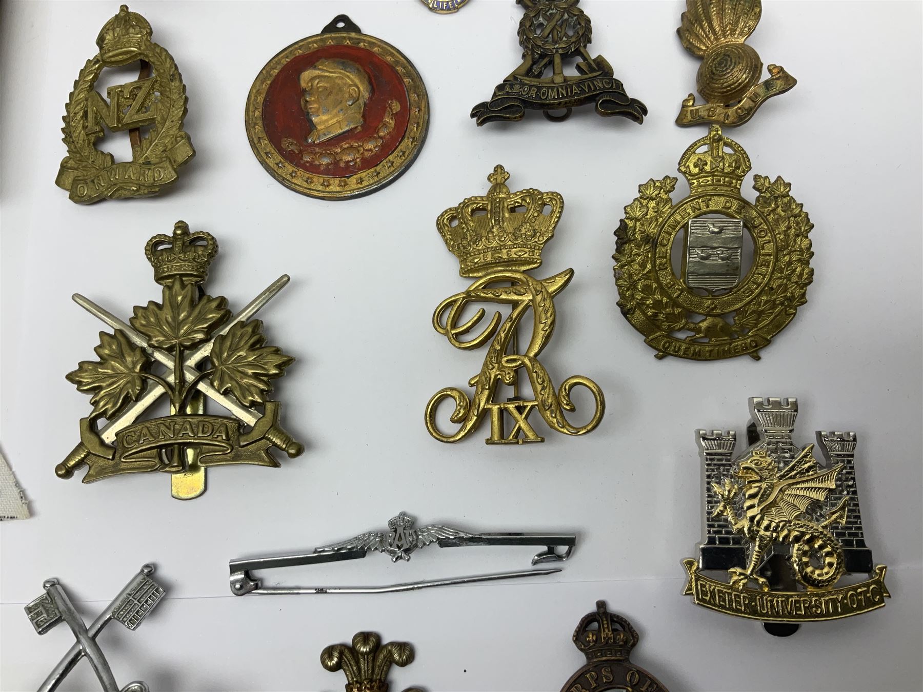 Collection of approximately sixty worldwide medals, metal badges, belt buckles, cloth badges, trench art, brass button stick etc