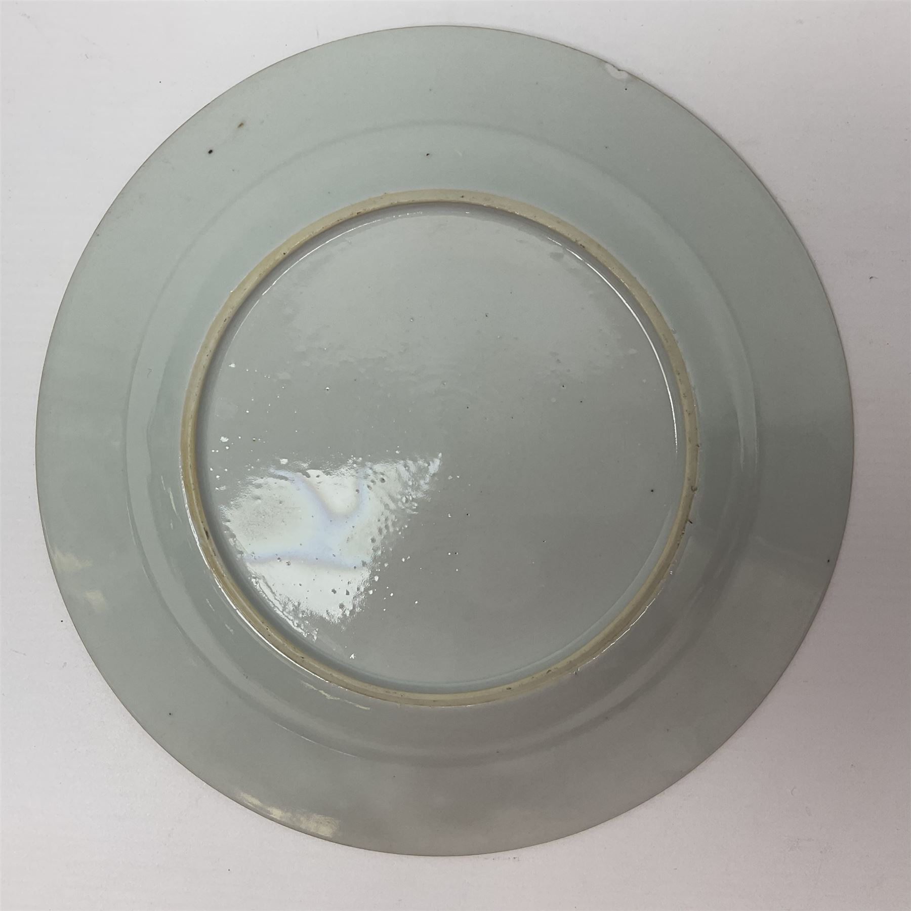 Three 18th century Chinese Famille Rose plates, the first example enamelled with blossoming peonies, rockwork and fence, the other two examples of similar design, decorated with blossoming peonies and sprigs within shaped inner borders, each approximately D23cm