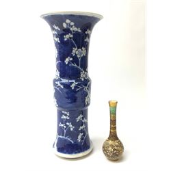 Japanese Meiji period miniature Satsuma bottle vase, painted with panels of figures below a green ground neck, H10cm together with a 19th/early 20th century Chinese blue and white Gu vase, painted with prunus flowers and bearing four character Kangxi mark to base, H25.5cm (2)