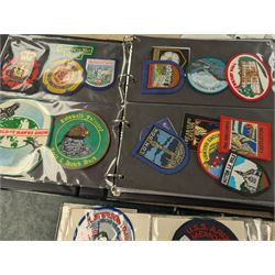 Large collection of souvenir cloth badges and vinyl stickers, mostly contained within albums