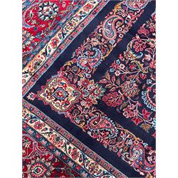 Persian Hamadan indigo ground carpet, the field decorated with central rectangle and outer band, overall floral pattern with cusped central medallion and surrounding leafy branches with palmettes, the border with scrolling branches decorated with further palmettes, within floral pattern guard stripes