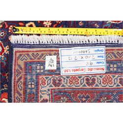 West Persian Mahal hand-knotted carpet, indigo field with central stylized angular medallion issuing an all-over Herati-inspired lattice of floral sprays, rosettes and geometric vinery in tone soft madder red, ivory and soft blue, principal border decorated with stylized palmettes, and angular vine motifs, flanked by multiple guard borders, with cotton fringe ends 