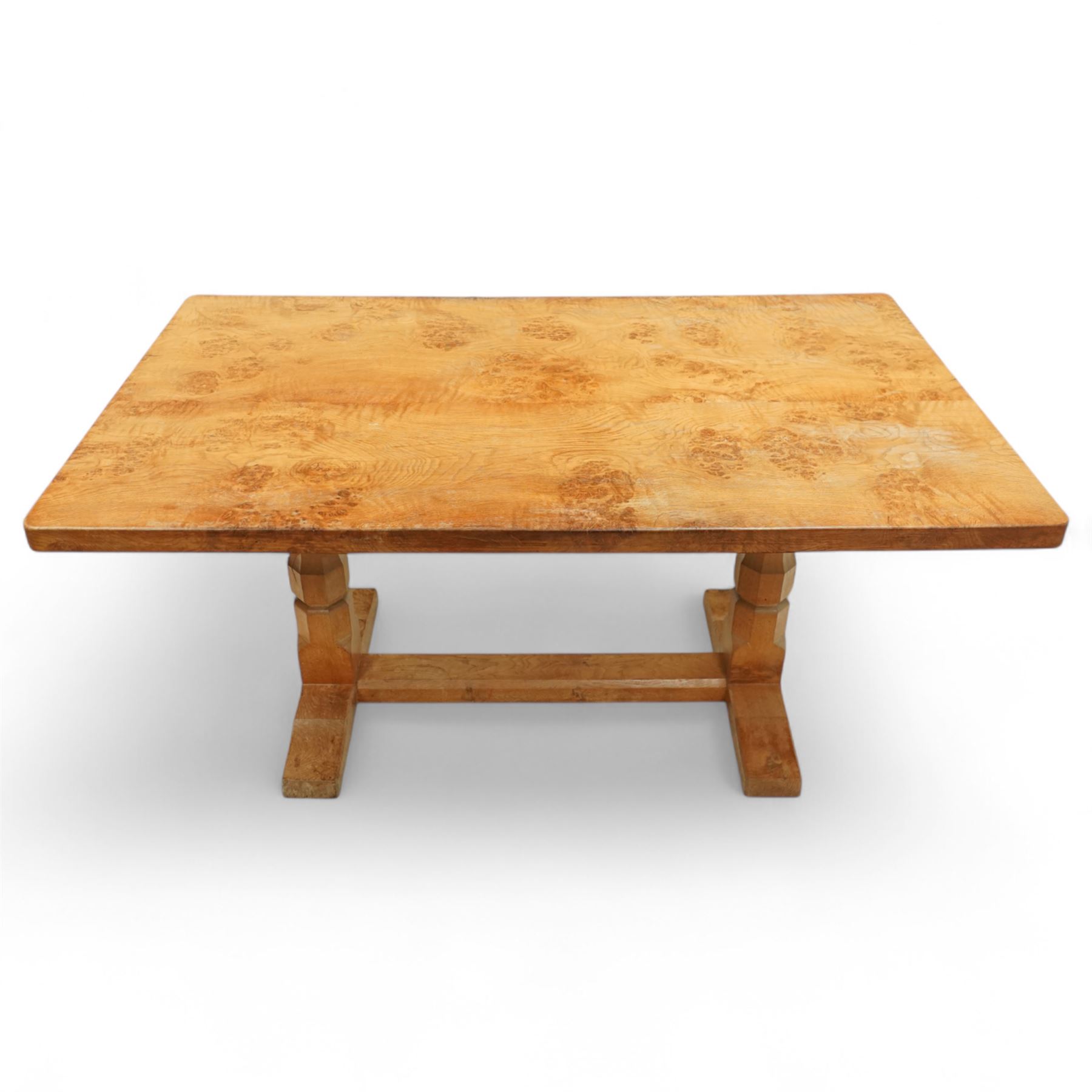 Mouseman - figured oak 5’ refectory dining table, rectangular top with burr figuring, raised on chamfered octagonal supports united by a stretcher, carved mouse signature to leg, by the workshop of Robert Thompson, Kilburn