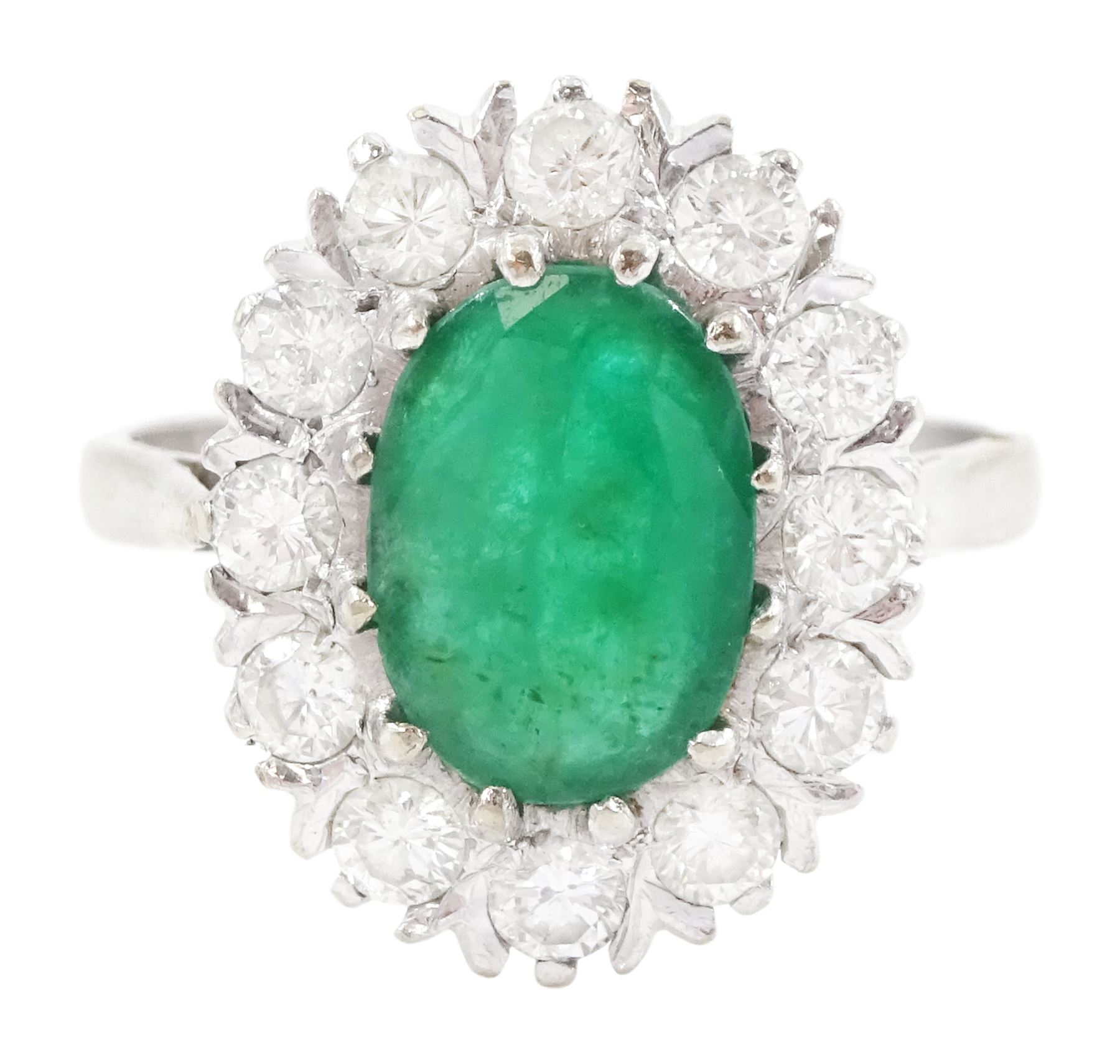 White gold emerald and diamond cluster ring, single oval cut emerald of approx 1.35 carat, surrounded by twelve brilliant cut diamonds, stamped 18ct, total diamond weight approx 0.85 carat