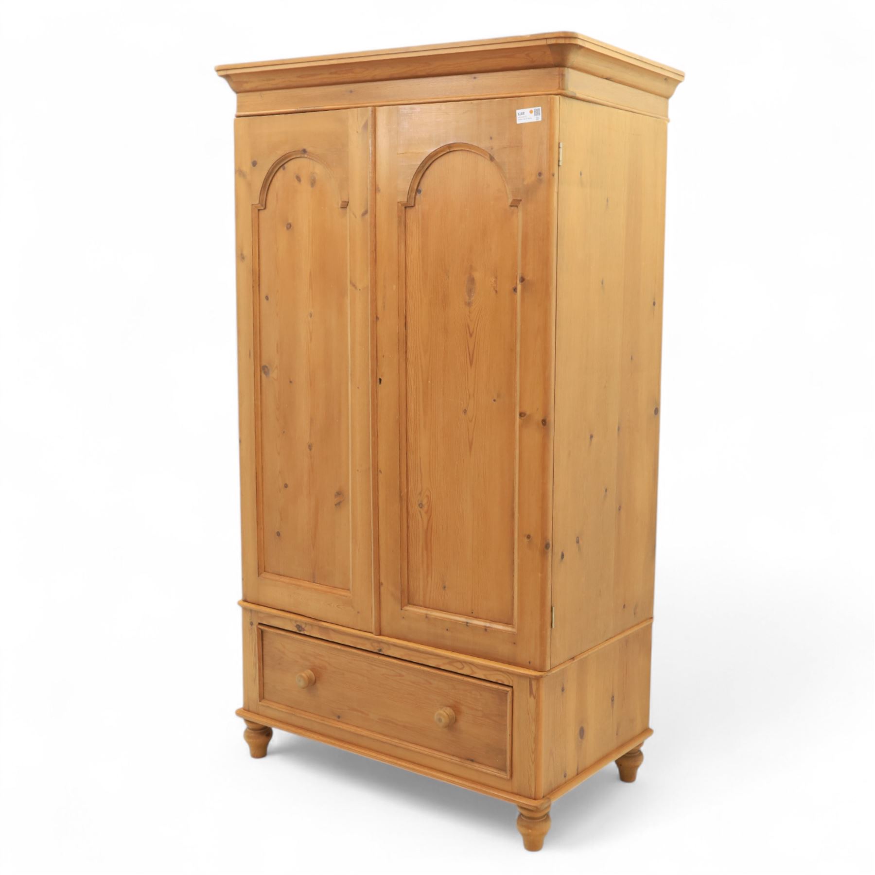 Two contemporary traditional-style wardrobes, projecting plain cornice above two arched moulded panel doors, above a full-width drawer fitted with turned wooden handles, raised on turned bun feet