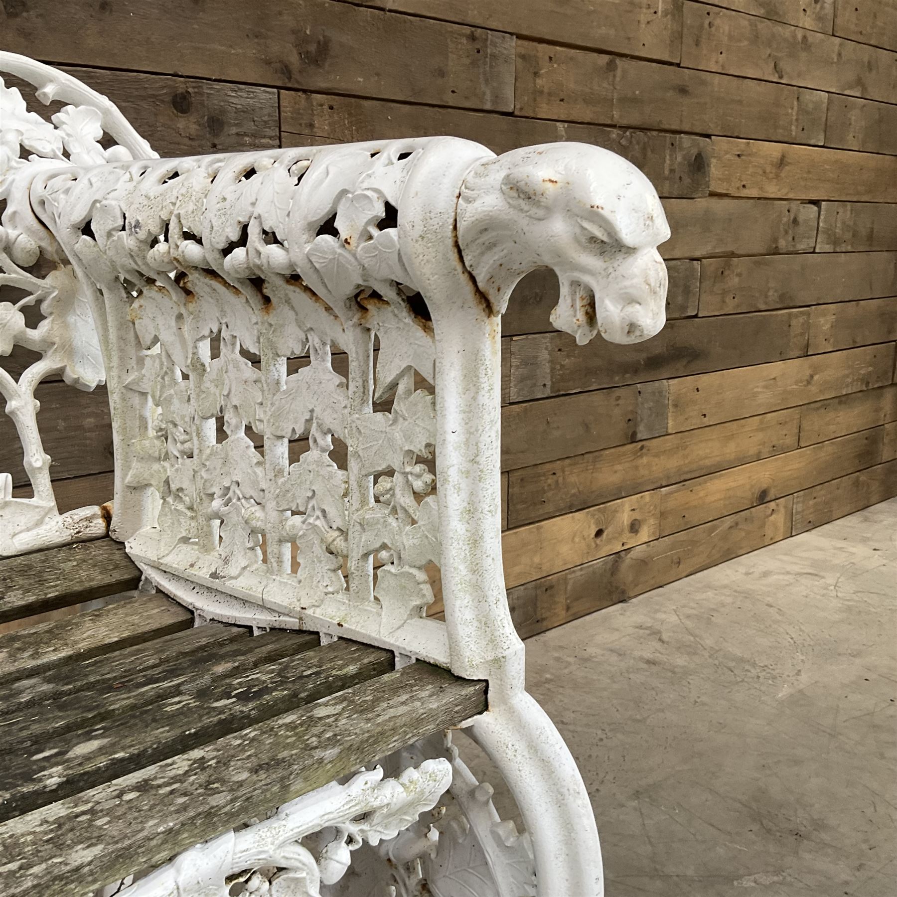 20th century Coalbrookdale design cast iron oak leaf and acorn armchair, white painted cast iron frame with slatted wooden seat, the pierced and shaped back decorated with scrolling oak branches and leafage, flanked by dog mask arm terminals over cabriole supports with paw feet