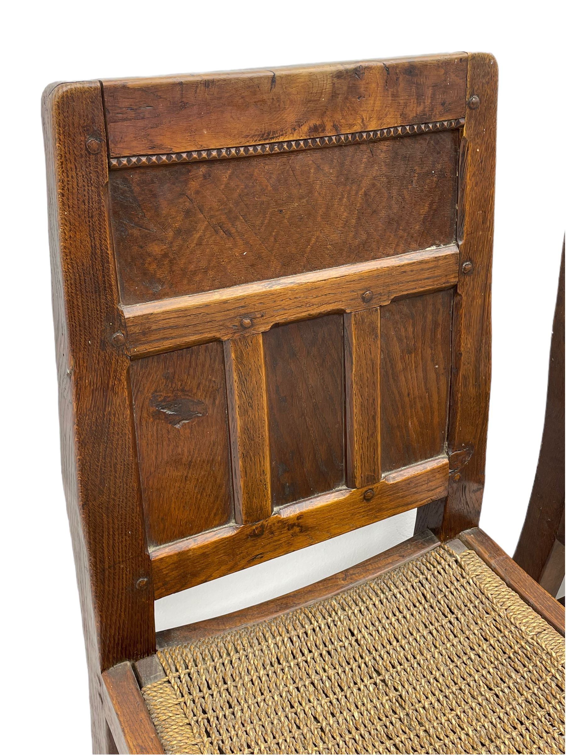'Gnomeman' set of three oak dining chairs, panelled backs over curved seat rails with drop in rope rush seats, turned front supports with collar joined by plain stretchers, two with carved seated gnome figures, painted

Provenance - This collection of early 'Gnomeman' furniture comes to us directly from the Whittaker family. The pieces were made by the vendor's father Thomas Whittaker in the 1930/40s for his own use. During this time, he lived in York and made items for himself and friends. Whittaker adopted the gnome as a signature and trademark after his move to Littlebeck, Whitby.