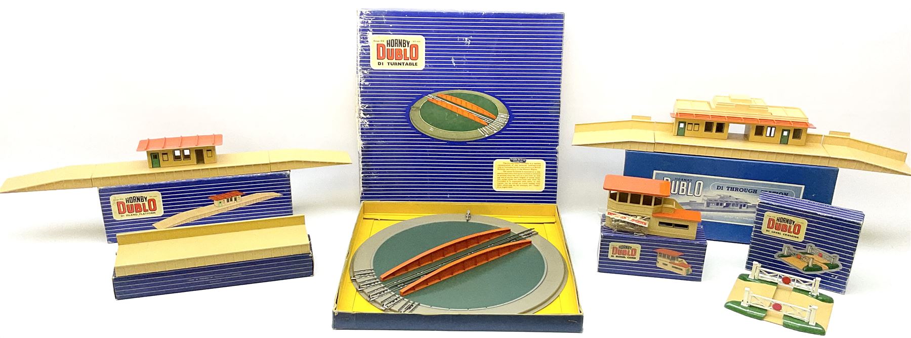 Hornby Dublo - six D1 accessories comprising Turntable; Through Station with white edges and separately boxed Platform Extension with Wall; Signal Cabin with orange roof and pack of station names; Level Crossing; and Island Platform; all boxed (6)
