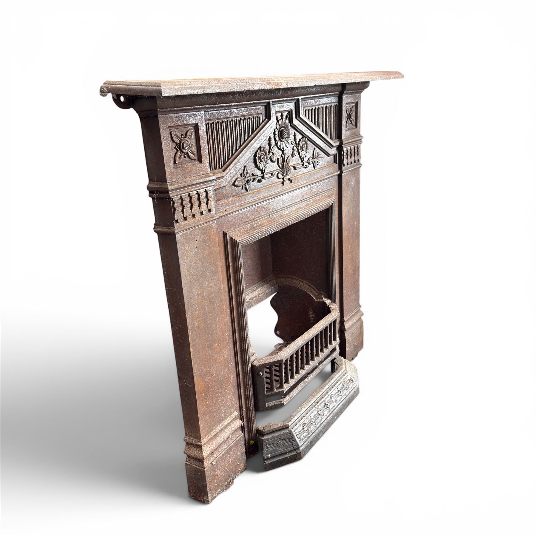 Late Victorian cast ion bedroom fireplace, decorated with floral poppy motifs and flluting
