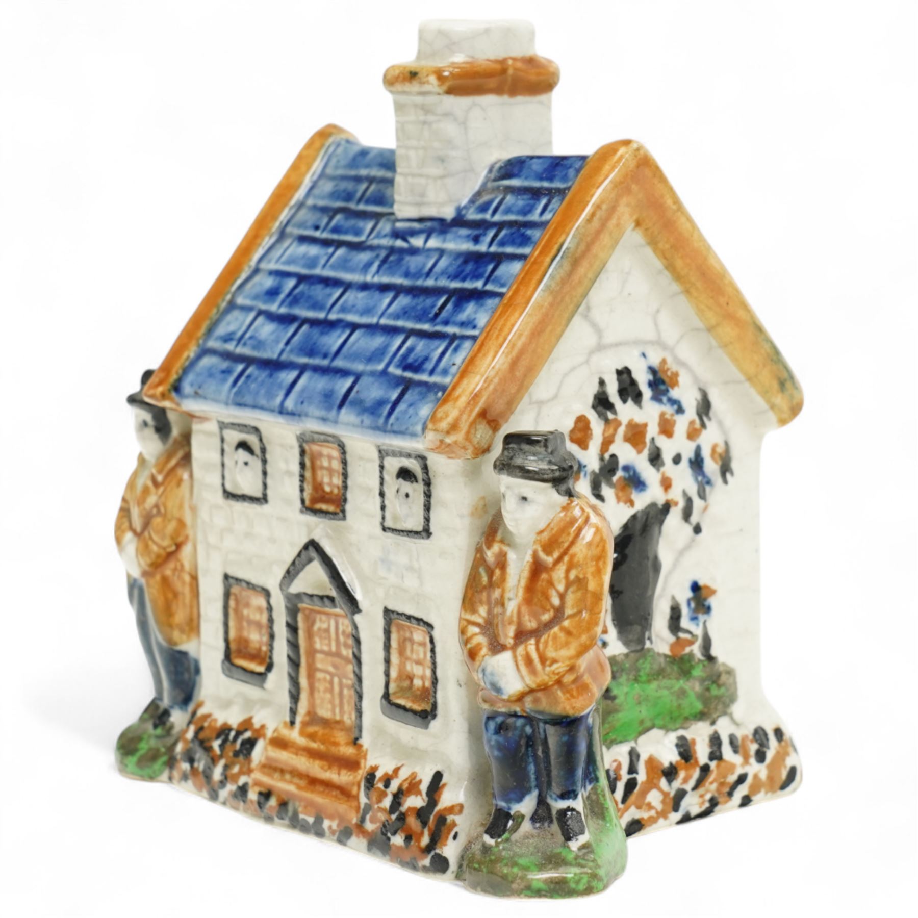 Yorkshire Prattware cottage, circa. 1820, in shades of blue, ochre and white, moulded in relief with two flanking gentlemen figures, H12cm 