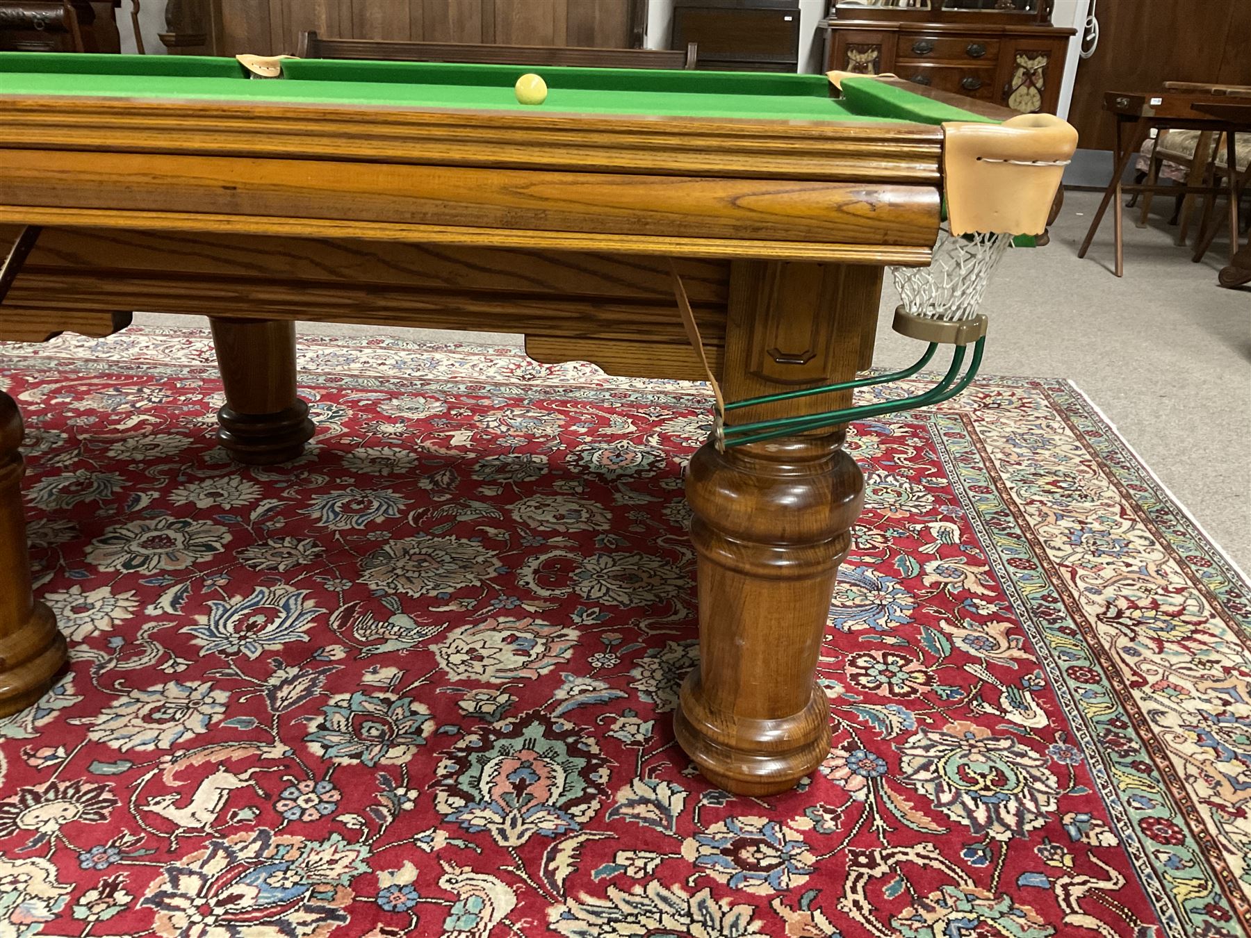 Late 20th century oak slate bed billiard table, on six turned column supports,  together with cues, ball set, baize brush, triangles and scoreboard 