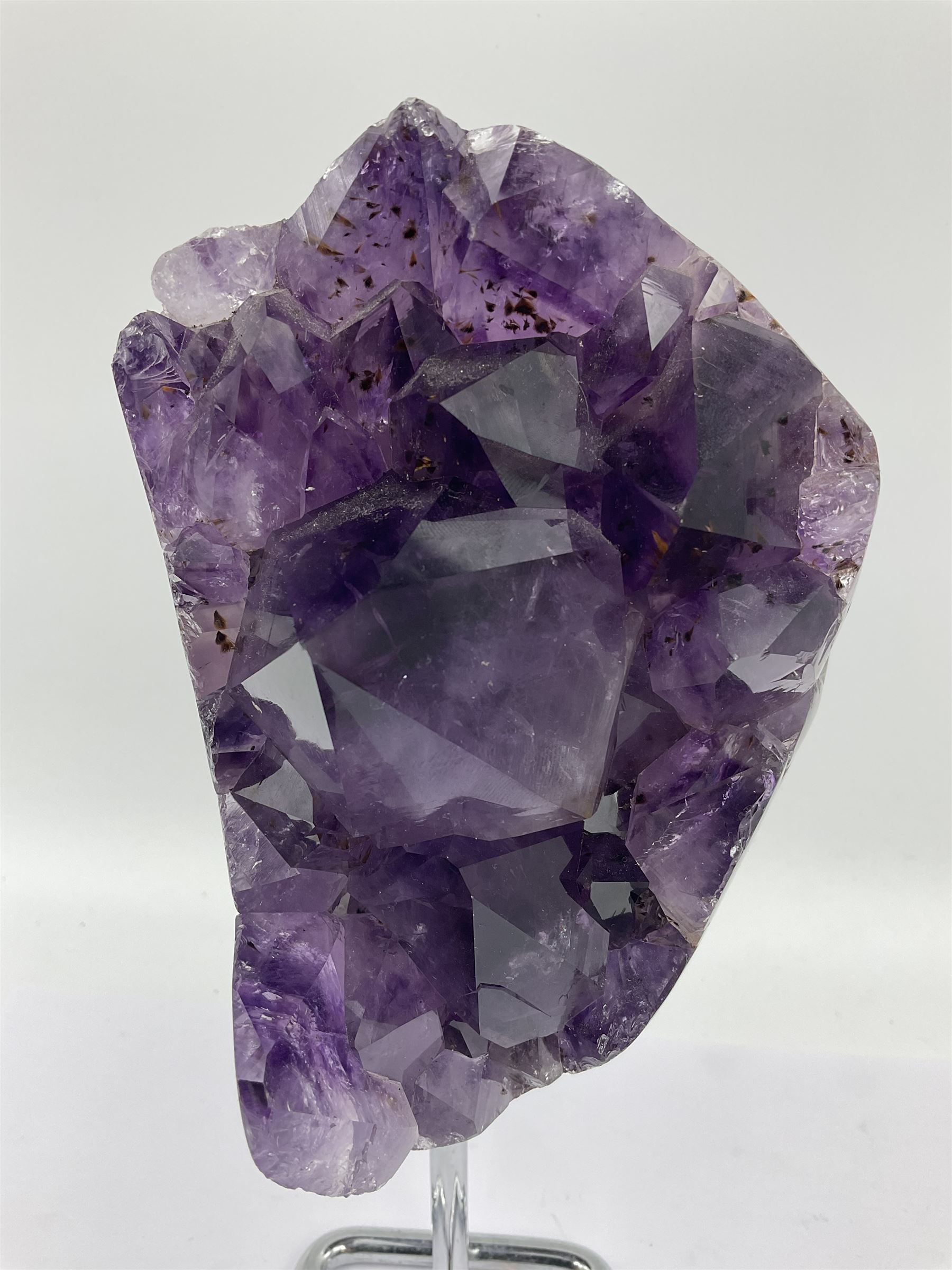 Amethyst crystal geode cluster, with large well-defined crystals, upon a metal stand, H21cm