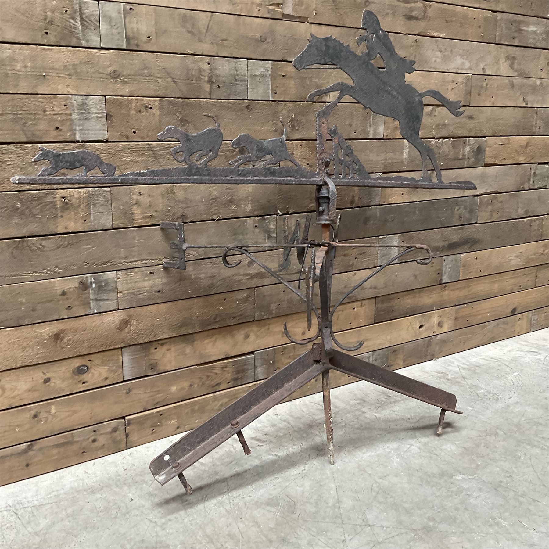 Black painted wrought iron weather-vane depicting hunting scene and compass points