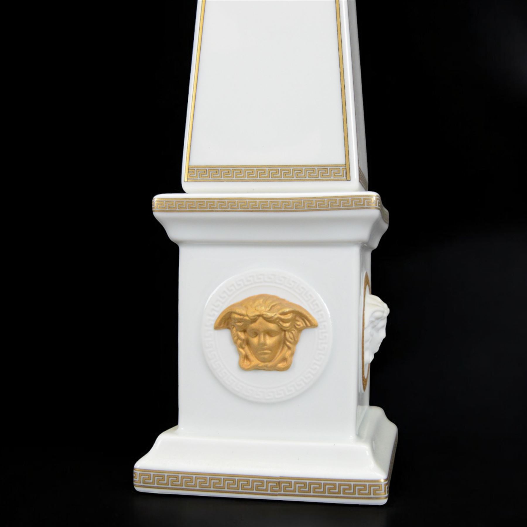 Pair of Rosenthal Versace Gorgona obelisks, each with relief moulded Medusa masks and gilt Greek key borders upon a white ground, both boxed, H38cm