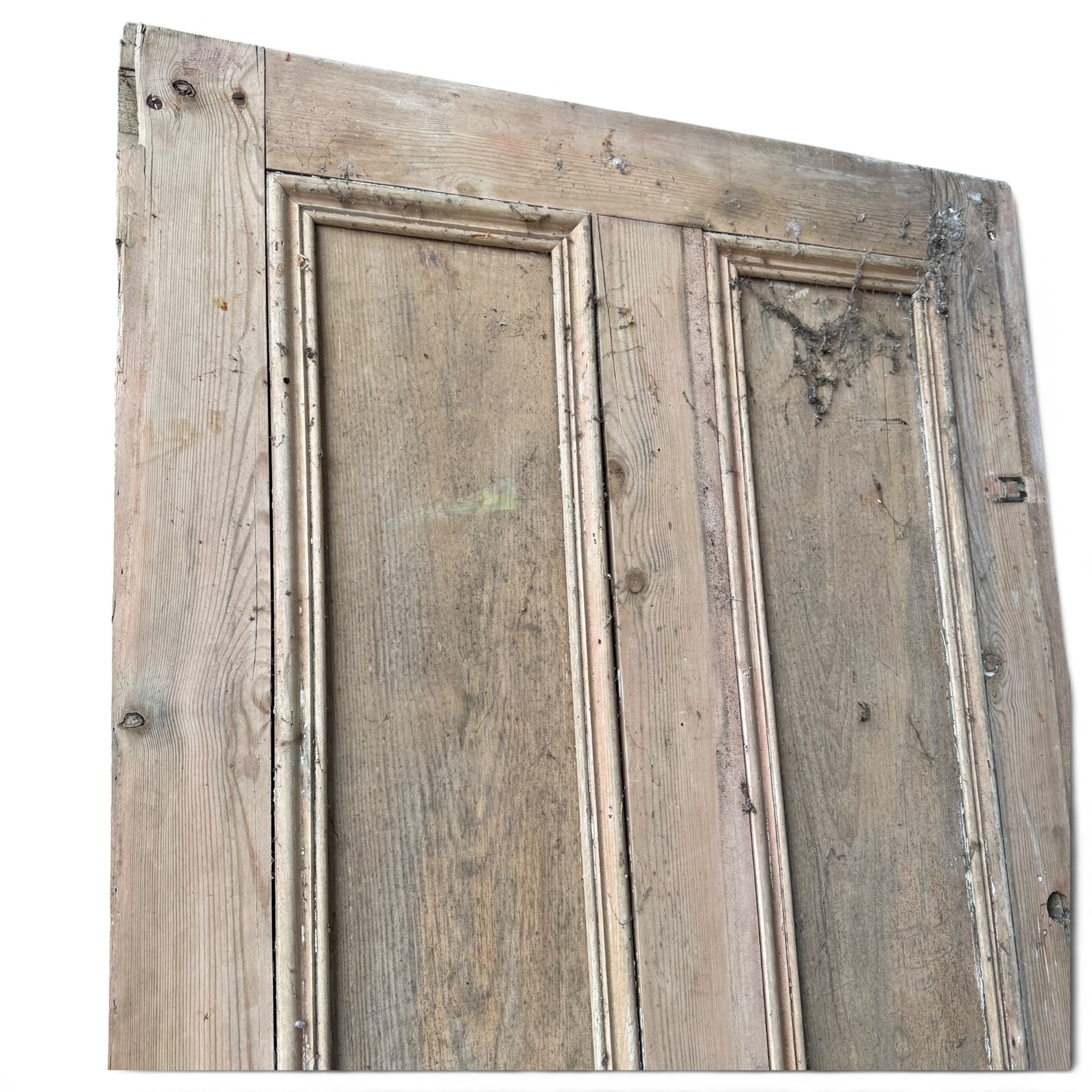 Victorian stripped pine four-panel door, the raised fielded panels within carved foliate and moulded surrounds, with iron lock and fittings and brass knob handle