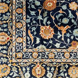 Persian Kashan carpet, navy field with an all-over design of scrolling vines, palmettes and rosettes in gold and pale blue, enclosed by multiple floral borders with stylised palmette motifs, originating from Central Iran