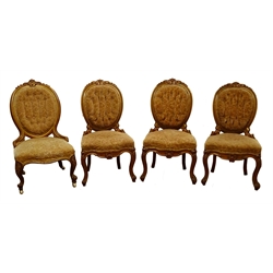  Set of three Victorian walnut and parcel gilt salon chairs, floral carved cresting rail, buttoned back and serpentine seat on acanthus carved cabriole legs, and a matching nursing chair (4)  