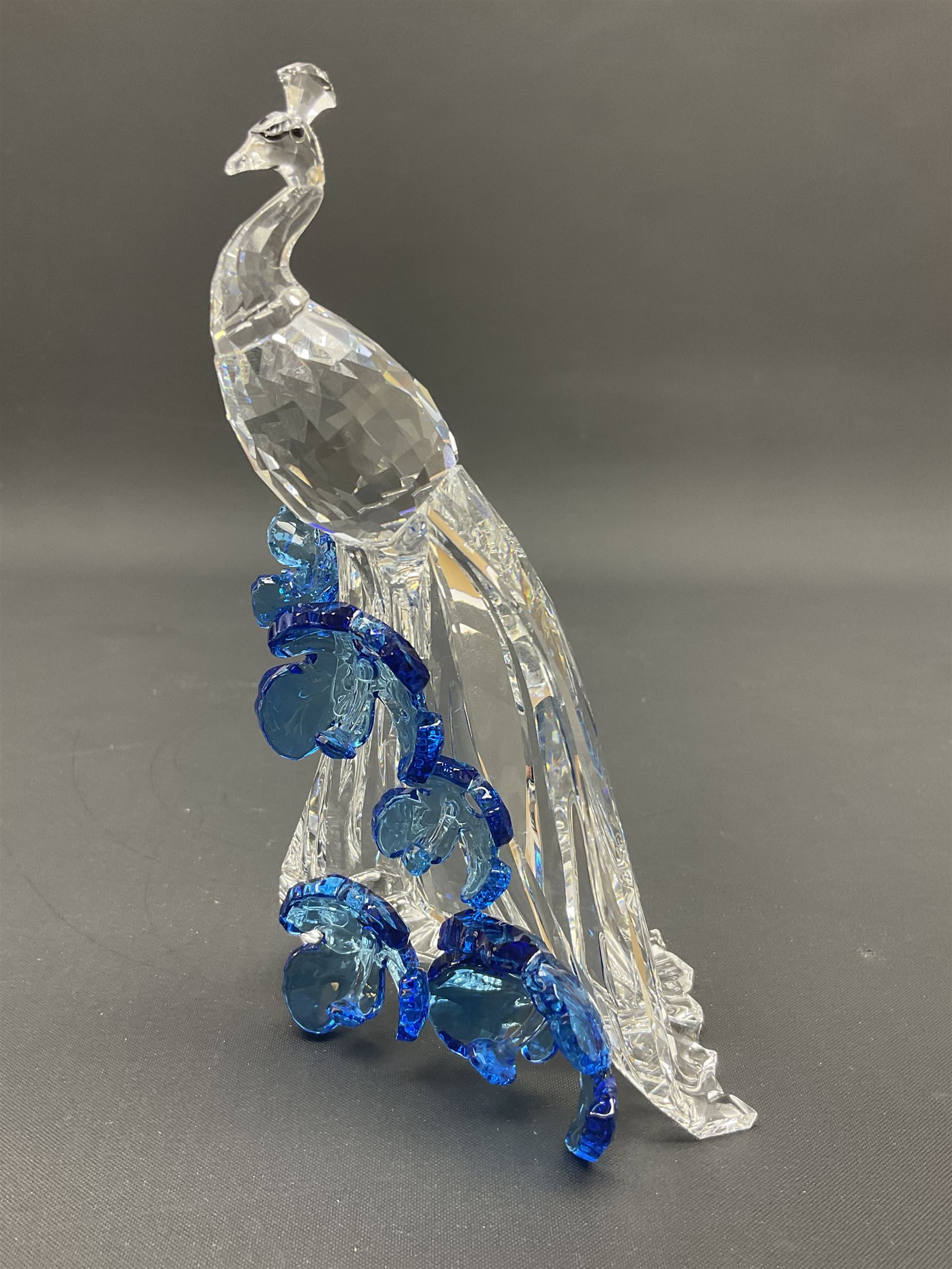 Swarovski Crystal animals, comprising white peacock, the tail with cascading blue flowers, perched eagle with yellow beak, ibex with frosted crystal horns and unicorn with frosted crystal horn, tallest H13cm