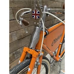 Fully restored vintage advertising bicycle with 2 stroke petrol engine, orange frame, tan leather seat