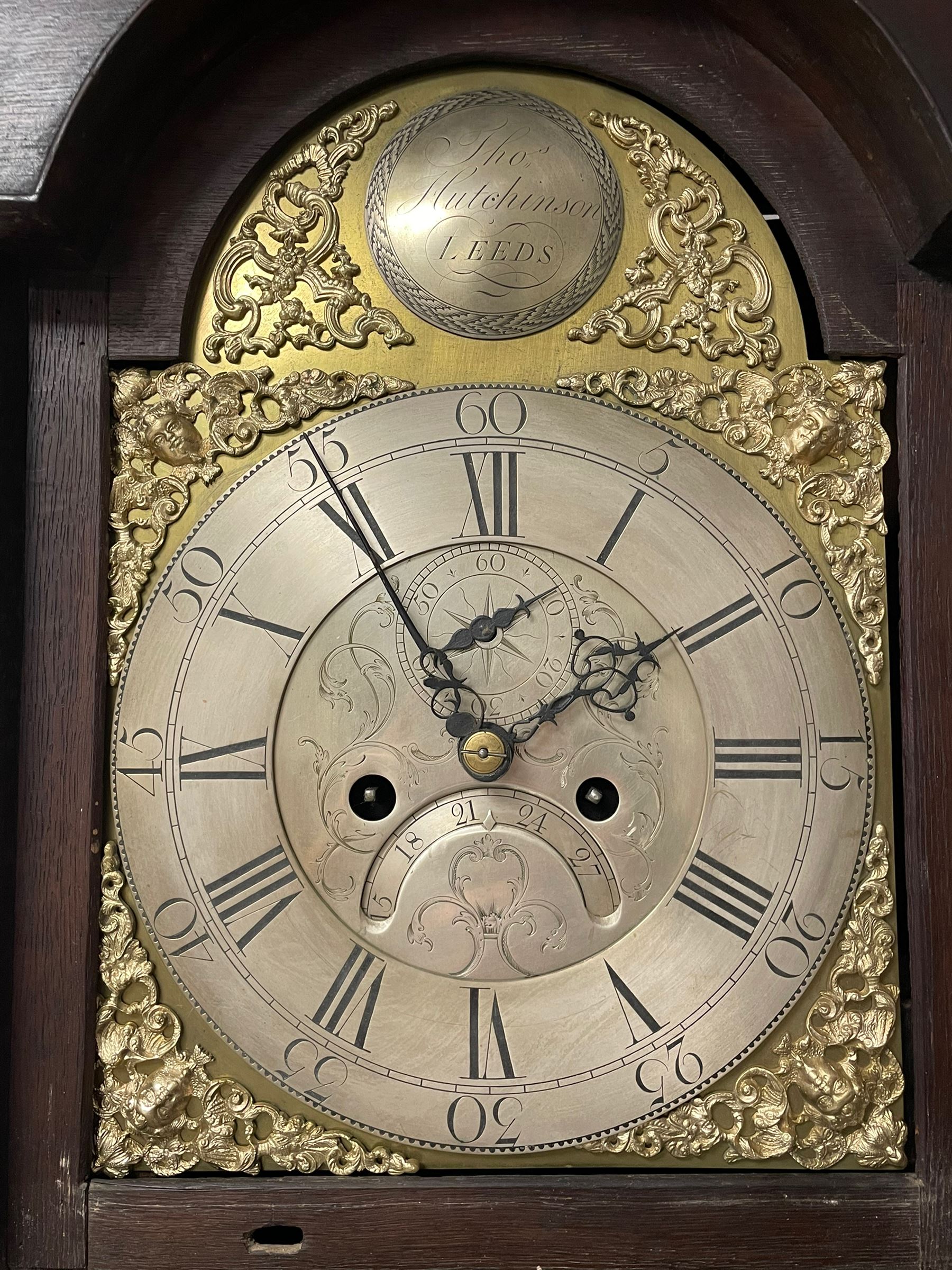 Thomas Hutchinson of Leeds - 18th century 8-day oak longcase clock with as broken arched  pediment and moulded cornice, with a conforming hood door flanked by plain turned pilasters with gesso capitals,  long trunk door with a wavy top on a square plinth with a raised panel, brass dial with cast spandrels,  engraved silvered dial centre and chapter ring with Roman numerals, five minute Arabic's and minute track, with pierced steel hands, seconds pointer,  arched calendar aperture and silvered boss engraved with the makers name to the break arch, dial pinned to a rack striking two train movement with a recoil anchor escapement. With weights and pendulum. Thomas Hutchinson is recorded as working in Leeds from 1760-90.
