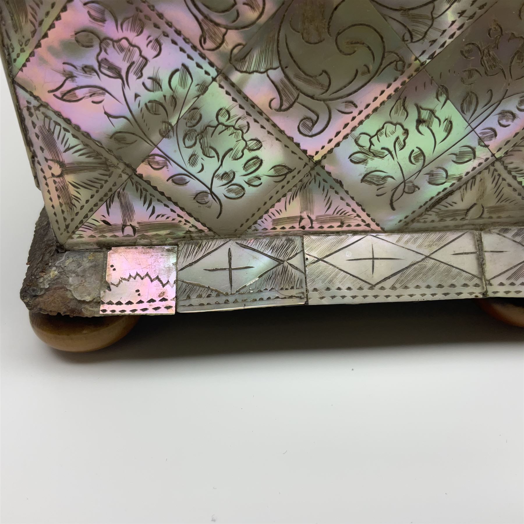 Victorian mother of pearl tea caddy, of rectangular bow-fronted form, the body with floral, bird and geometric engraved mother of pearl panels, white metal shield plaque to the cover inscribed with the initials G.J.A and similar escutcheon, the two division interior with ivory edging and two panelled mother of pearl lids, on four vegetable ivory bun feet L20cm, together with a similar style mother of pearl card case (2) This item has been registered for sale under Section 10 of the APHA Ivory Act